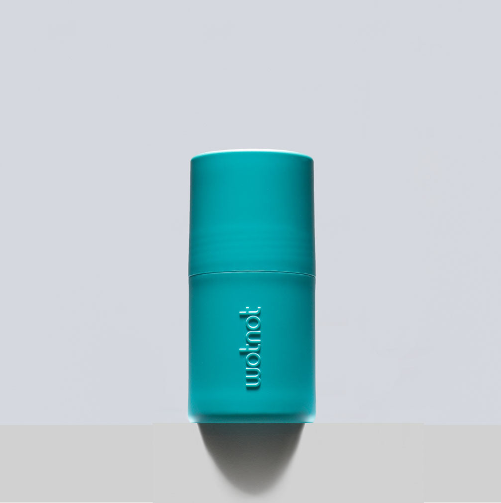 Refillable sunscreen roll-on applicator in turquoise from Wotnot Naturals on a neutral background.
