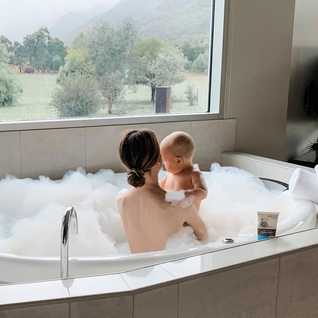 Mother giving baby a bubbly bath using Wotnot's baby wash