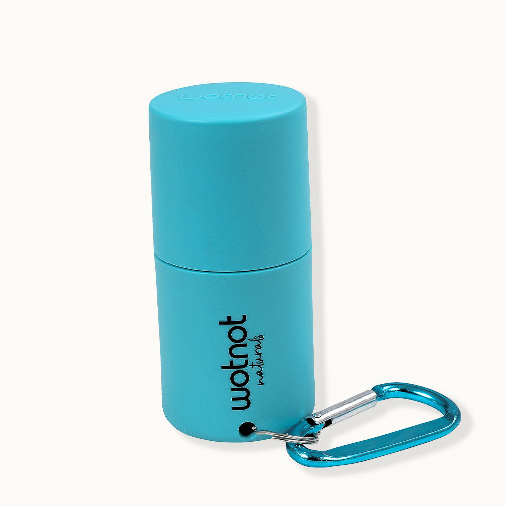 Refillable sunscreen roll-on applicator in turquoise from Wotnot Naturals on a neutral background.